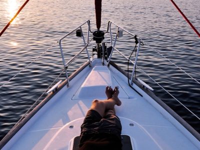 man lying on white boat